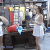 Two women standing in a warehouse talking.