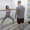 Man helping woman do exercises.